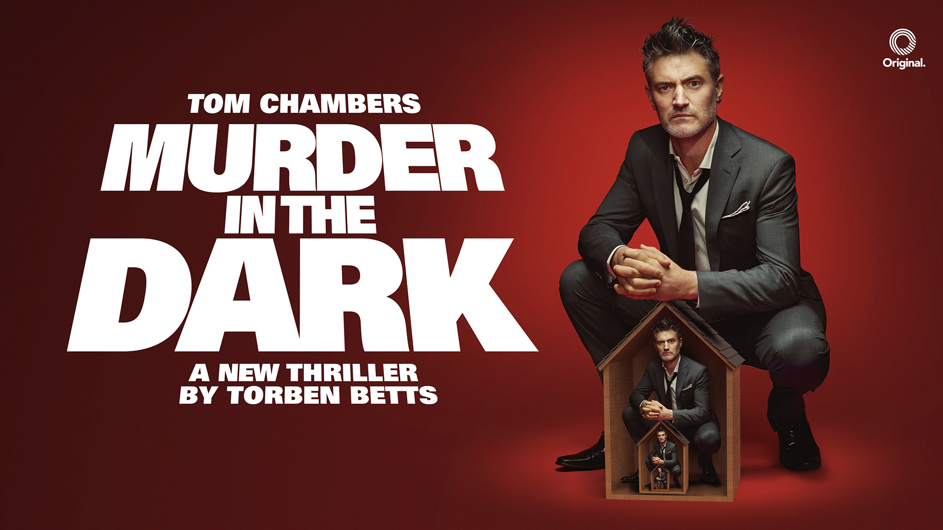 Promotional image for the thriller Murder in the Dark by Torben Betts, featuring Tom Chambers. The background is red with white text. Tom Chambers is pictured in a suit, crouching and also sitting inside a small house prop.