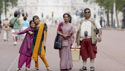 A Bangladeshi family - two young girls, a young woman and a large middle-aged man - stand on The Mall (the large promenade leading from Trafalgar Square to Buckingham Palace