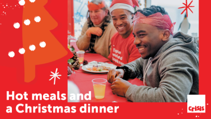 A promotional poster for Crisis at Christmas. A picture sits inside a red background that shows a Christmas tree and the caption Hot meals and a Christmas dinner. The picture shows three people eating Christmas dinner together and smiling - the person in the middle is a volunteer wearing their Crisis t-shirt