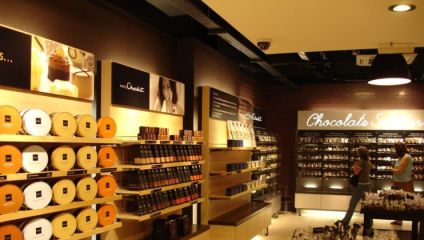 Two women peruse the shelves, with their rows and rows of chocolate boxes, in Hotel Chocolat in Brighton