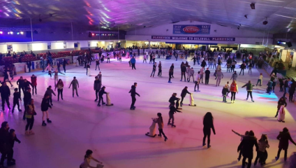 Ice skaters, seen from above, under purple light at Planet Ice Altrincham