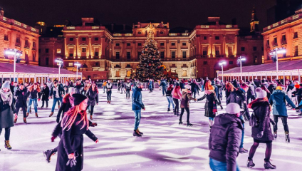 Hundreds of people ice skate on the famous Somerset House ice rink, in the Edmond J. Safra Fountain Courtyard, at night