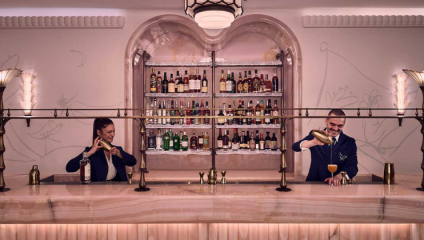 Two smiling bartenders mix drinks at the bar The Painters' Room in London's Claridges Hotel