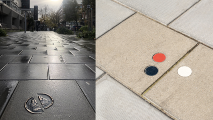 A split image: Left side shows a wet, reflective sidewalk with a metal coin-like emblem embedded in a tile, lined with buildings and a tree. Right side presents a close-up of a sidewalk with three embedded circular markers in red, blue, and white.