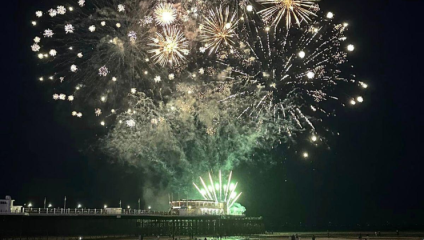 Fireworks shoot off from Worthing Pier, ahead in the distance, and balloon into huge displays in the sky above Worthing.