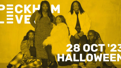 A group of five individuals posing together against a yellow background with Peckham Levels partially visible on the left. Text on the right reads 28 Oct '23 Halloween. The group is fashionably dressed, with one person seated on a stool and others standing or sitting on the floor.