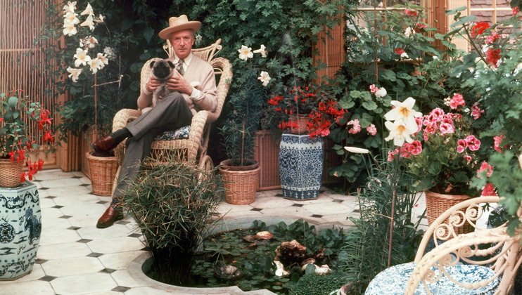 Cecil Beaton with his pug in the winter garden at Reddish House