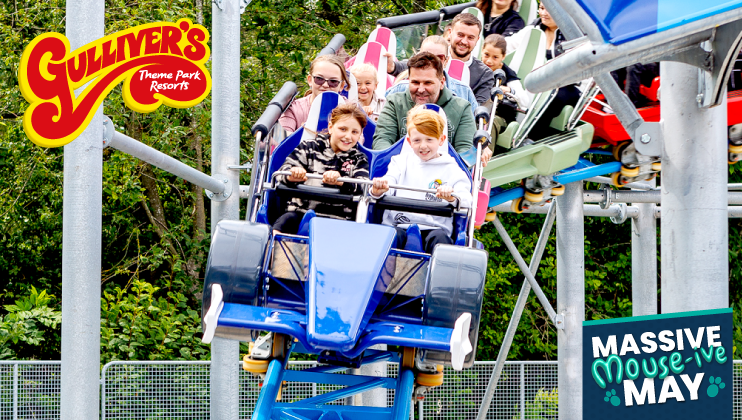 People laughing and enjoying a thrilling ride on a roller coaster at Gulliver's Theme Park Resorts. The ride features a blue car, and several riders lift their hands excitedly. The image promotes an event called Massive Mouse-ive May in vibrant text.