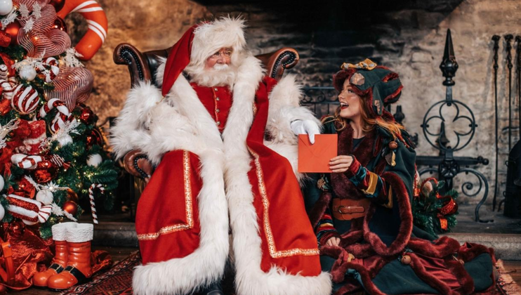 An elf gives Santa a Christmas card at The Grotto in The Trafford Centre