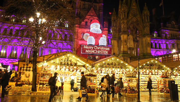 Above the Christmas market in Cathedral Square, a giant Santa light installation sits atop a sign, in lights, that reads Merry Christmas, Manchester