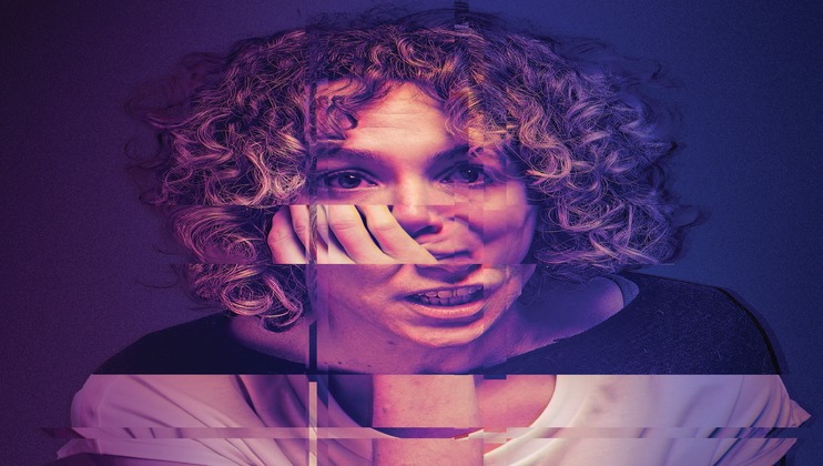 A person with curly hair rests their face on their hand, looking forward. The image has a glitch effect with horizontal lines and distortions, creating a fragmented and abstract appearance. The background is a gradient of purple and blue tones.