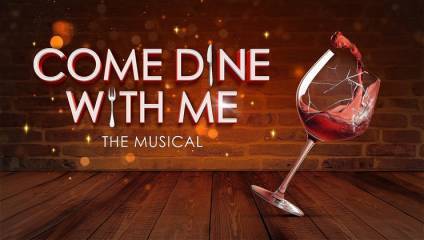 Graphic image promoting Come Dine With Me: The Musical. The background features a brick wall with floating light particles. The title text is in large, bold letters, with a wine glass tilting and red wine splashing out, depicted in the foreground.