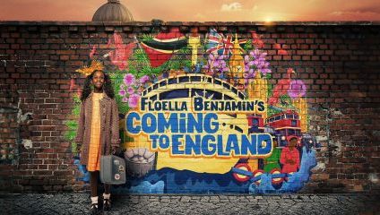 A young girl stands smiling against a vibrant mural on a brick wall that reads Floella Benjamin's Coming to England. The mural includes a ship, flowers, flags, and a sunset. The girl holds a small suitcase, symbolizing her journey.