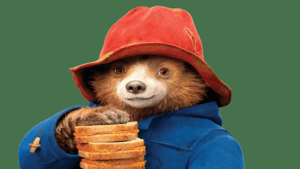 A friendly-looking anthropomorphic bear wearing a red hat and blue coat is holding a stack of sandwiches in one paw. The bear is smiling and looking directly at the viewer.