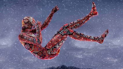 A person covered in a colorful, intricate pattern reminiscent of ornate carpets is depicted floating mid-air against a moody, snowy background. The figure appears to be falling or suspended, with limbs bent and body slightly arched.