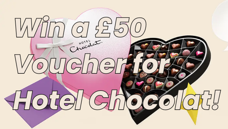 A heart-shaped box of chocolates with an assortment of colorful chocolates inside. The box is pink and white with a white ribbon and the brand name Hotel Chocolat on it. Overlaid text reads, Win a £50 Voucher for Hotel Chocolat!.