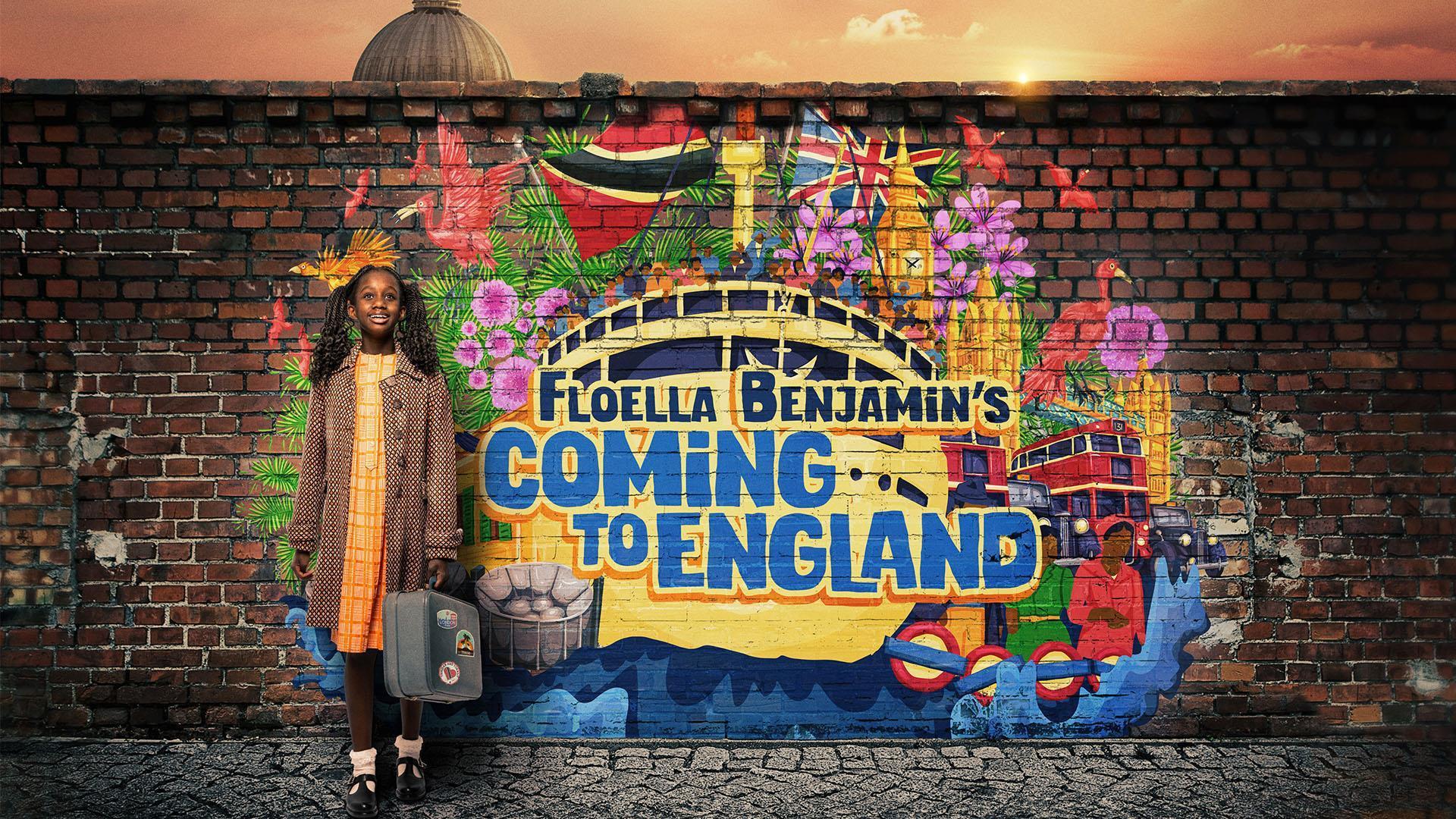 A young girl stands smiling against a vibrant mural on a brick wall that reads Floella Benjamin's Coming to England. The mural includes a ship, flowers, flags, and a sunset. The girl holds a small suitcase, symbolizing her journey.