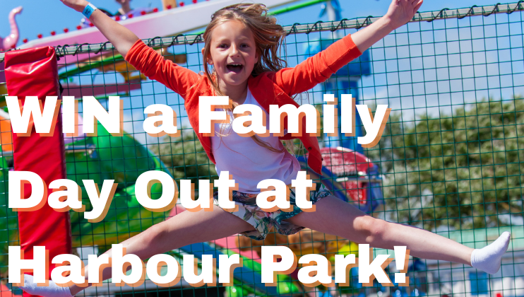 A young girl with long blonde hair is jumping joyfully on a trampoline at a vibrant amusement park. She is wearing a bright orange jacket and denim shorts. The image has bold white text that reads, WIN a Family Day Out at Harbour Park!.