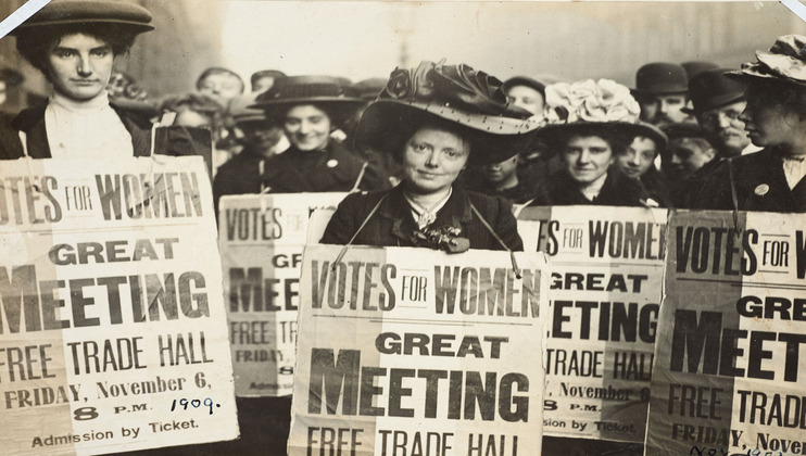 Historical photo of women holding signs promoting a suffrage meeting for women’s right to vote, 1909 Credit London Museum.